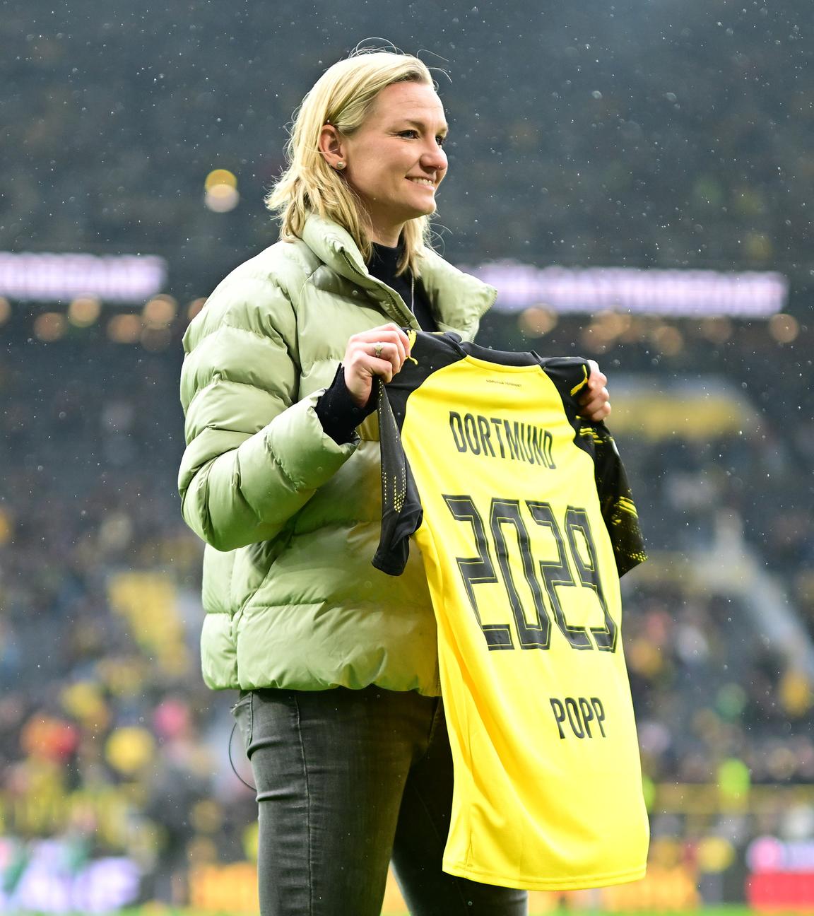 Die deutsche Fußballspielerin Alexandra Popp präsentiert stolz ihr Trikot mit dem Ende der kommenden Vertragslaufzeit bei ihrem neuen Verein, dem BVB