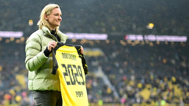 Die deutsche Fußballspielerin Alexandra Popp präsentiert stolz ihr Trikot mit dem Ende der kommenden Vertragslaufzeit bei ihrem neuen Verein, dem BVB