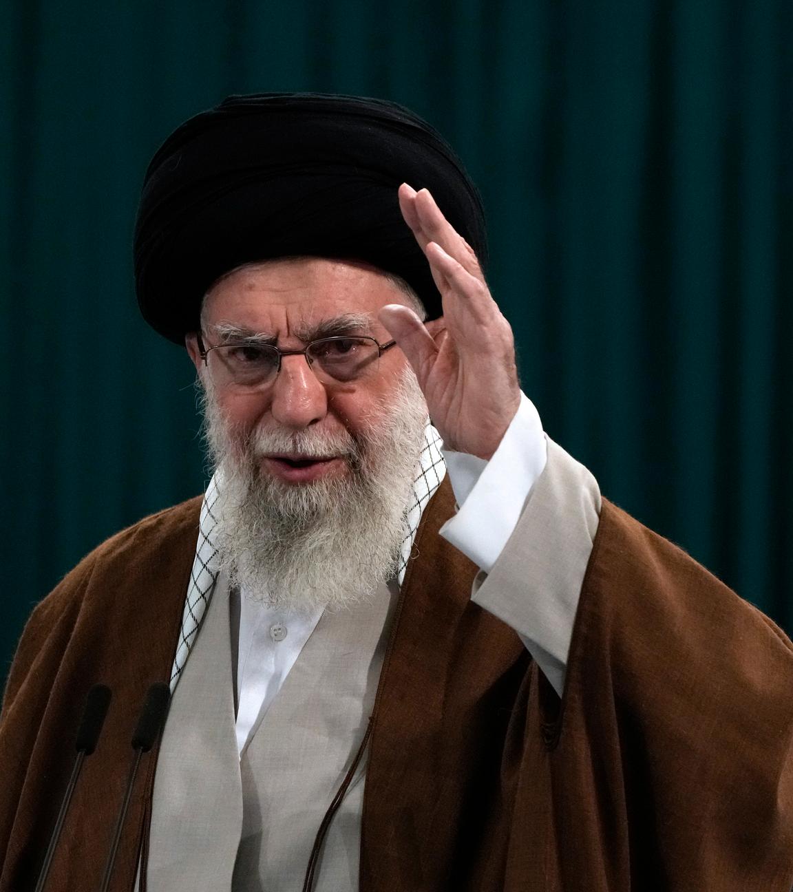 Ajatollah Ali Chamenei hebt seine Hand und winkt jemandem zu.