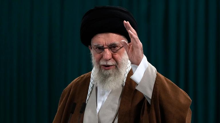 Ajatollah Ali Chamenei hebt seine Hand und winkt jemandem zu.