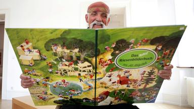 Ali Mitgutsch mit Riesenwimmelbuch, aufgenommen im Bilderbuchmuseum in Troisdorf 