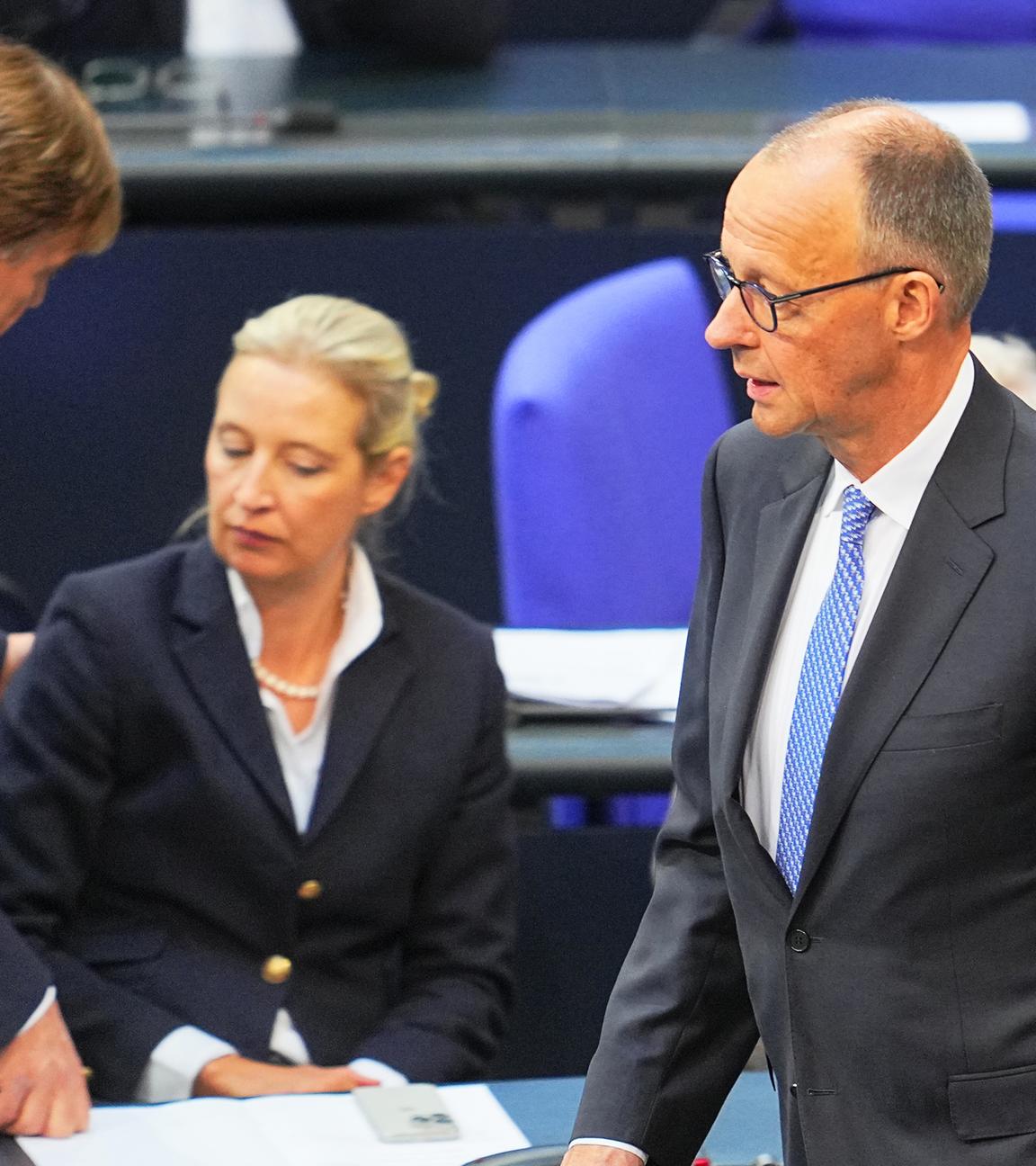 Archiv:  Der designierte Bundeskanzler Friedrich Merz (CDU, r) reagiert im Bundestag bei der Kanzlerwahl. Im Hintergrund unterhalten sich Bernd Baumann (l), erster parlamentarischer Geschäftsführer der AfD-Bundestagsfraktion, und Alice Weidel, Bundes- und Fraktionsvorsitzende der AfD. 