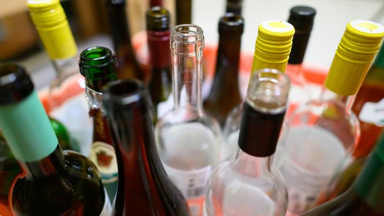 20.01.2025, Sachsen, Dresden: Leere Wein- und Sektflaschen stehen in einer Kiste.