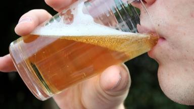 Ein Jugendlicher trinkt ein Glas Bier