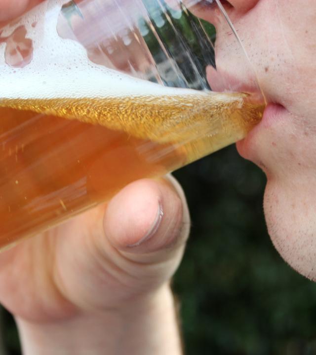 Ein Jugendlicher trinkt ein Glas Bier