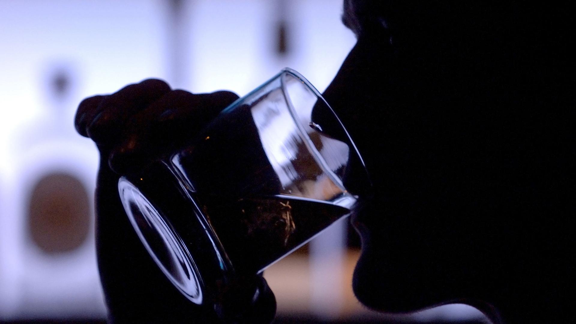 Ein Barbesucher trinkt Whiskey aus einem Tumbler (Symbolbild).