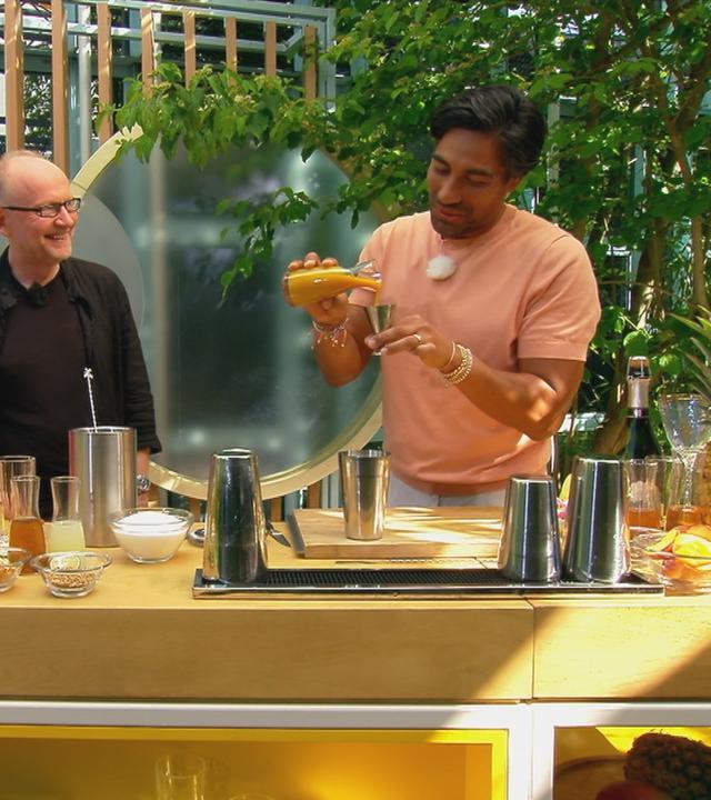 Nic Shanker bereitet einen Drink zu, waährend Nadine Krüger und Dieter Falk zuschauen.