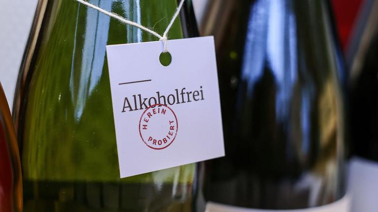 Ein Zettel, der um eine Weinflasche gebunden wurde, trägt die Aufschrift "Alkoholfrei".
