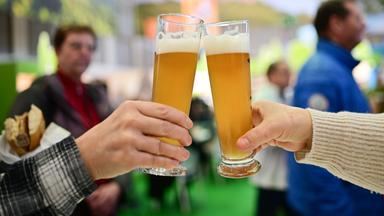 Zwei Personen stoßen mit einem alkoholfreien Bier an.