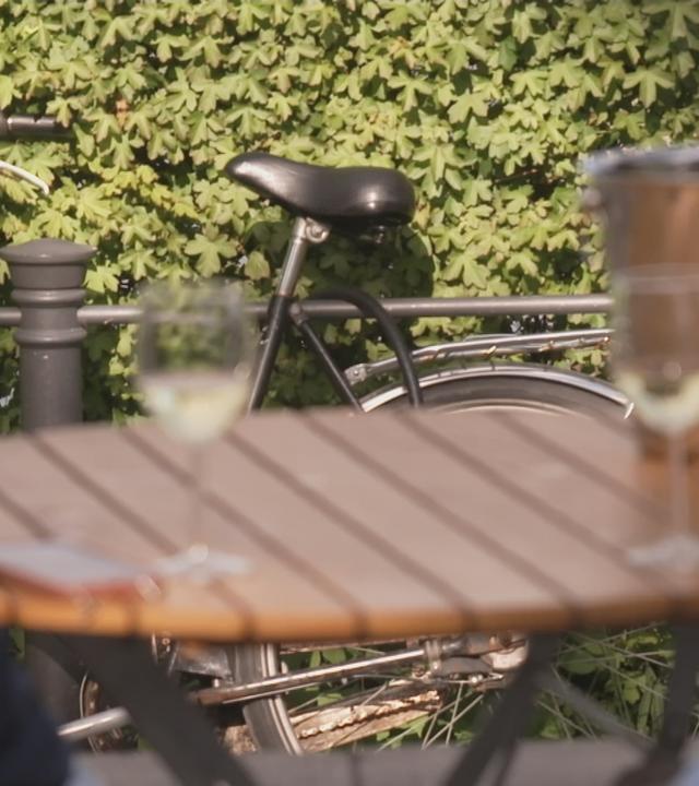 zwei Weingläser und ein Fahrrad im Hintergrund 