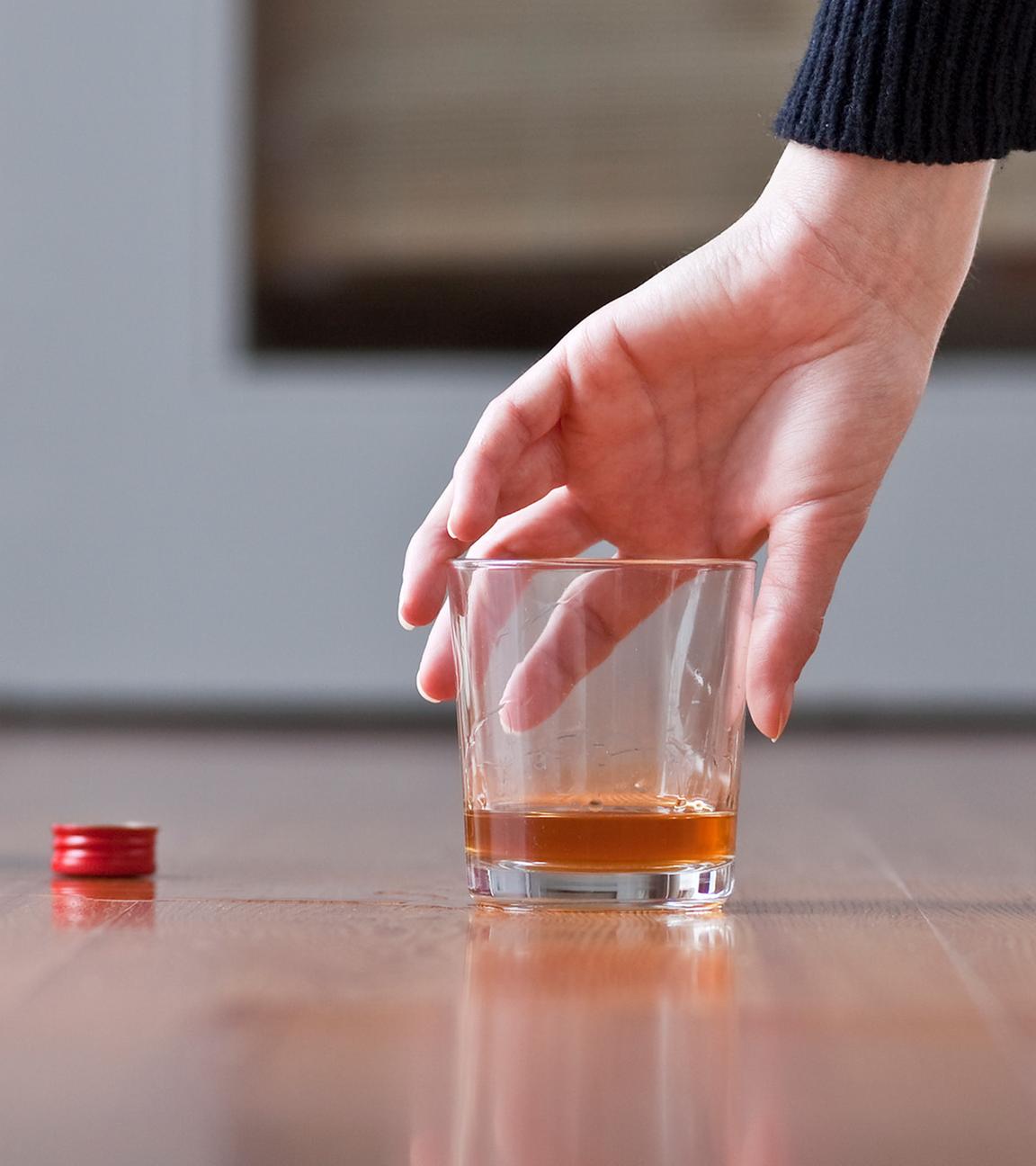 Eine Frau greift nach eine Glas mit Rum. (Symbolbild)