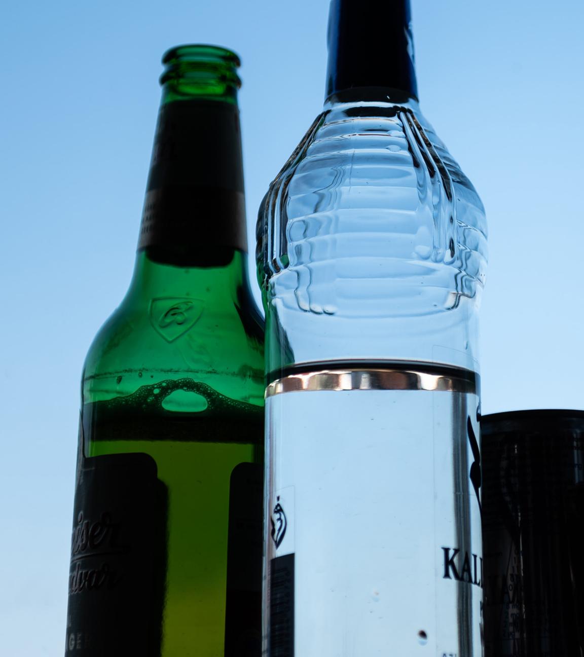 Verschiedene alkoholische Getränke stehen auf der Fensterbank in einem Zimmer.