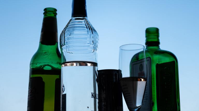 Verschiedene alkoholische Getränke stehen auf der Fensterbank in einem Zimmer.