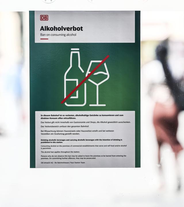 Ein Hinweisschild auf das Alkoholverbot hängt am Eingang zum Hauptbahnhof. Zu sehen eine durchgestrichene Flasche und Glas auf grünem Hintergrund.