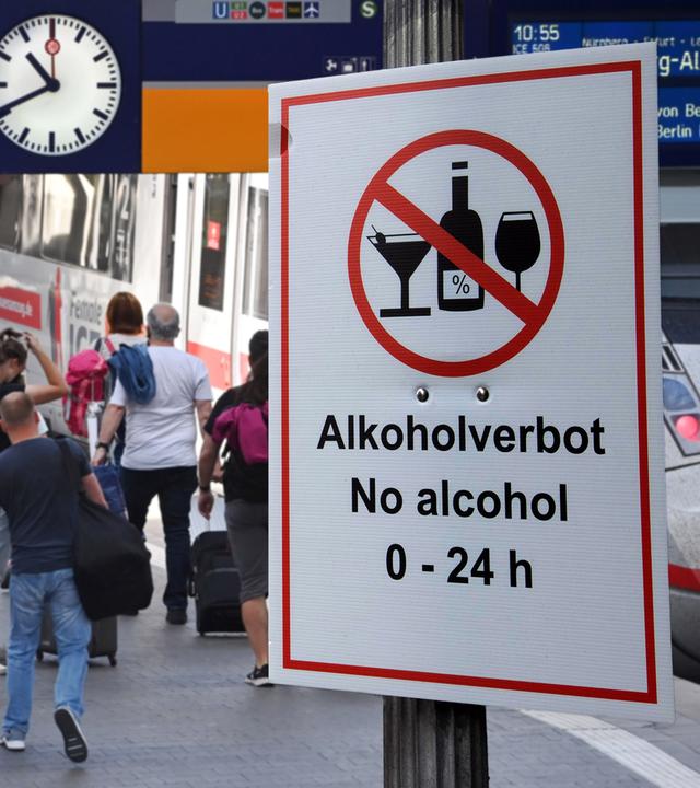 Ein Alkoholverbotsschild an einem Bahnhof.