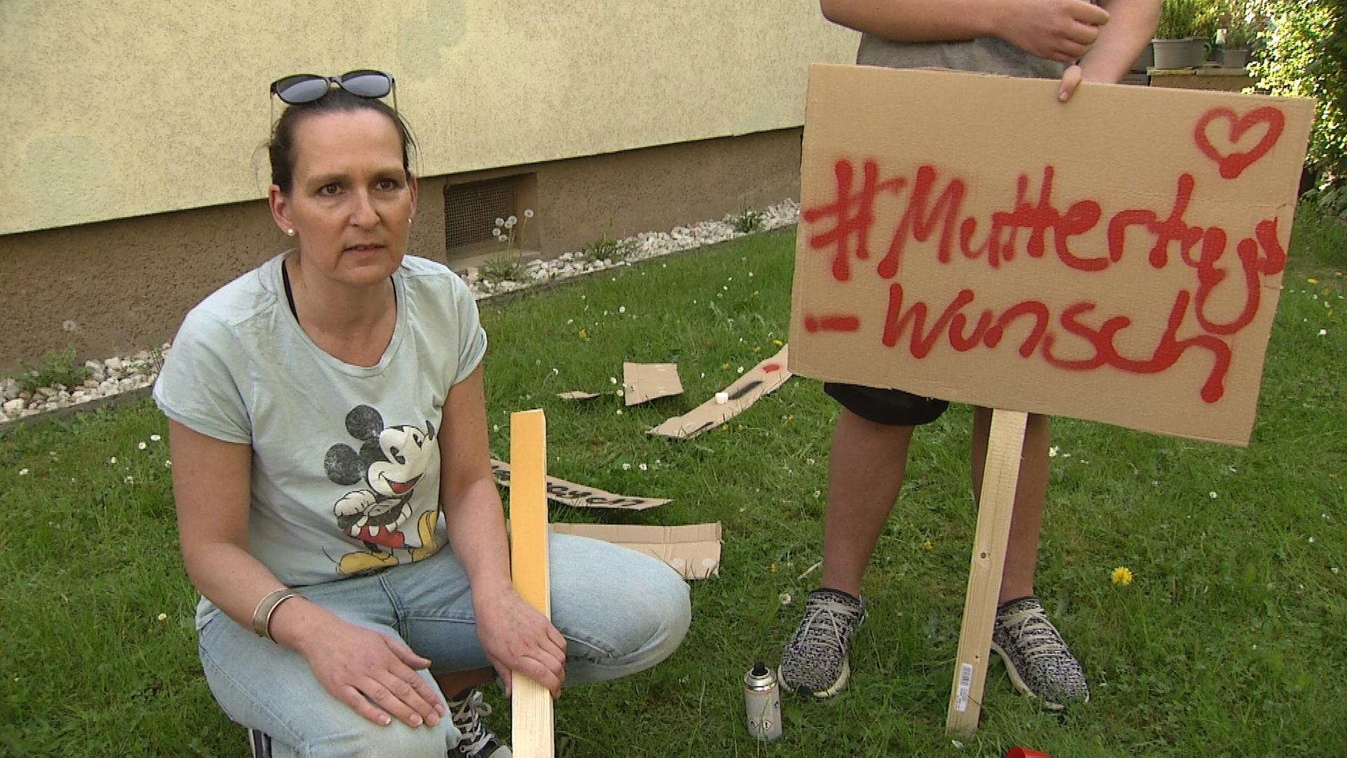 Alleinerziehende mit Plakat für Demo gegen Kinderarmut