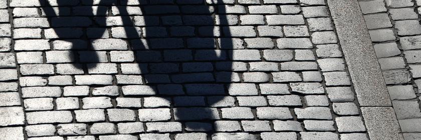 Die Schatten einer erwachsenen Person und eines Kindes sind zu sehen.