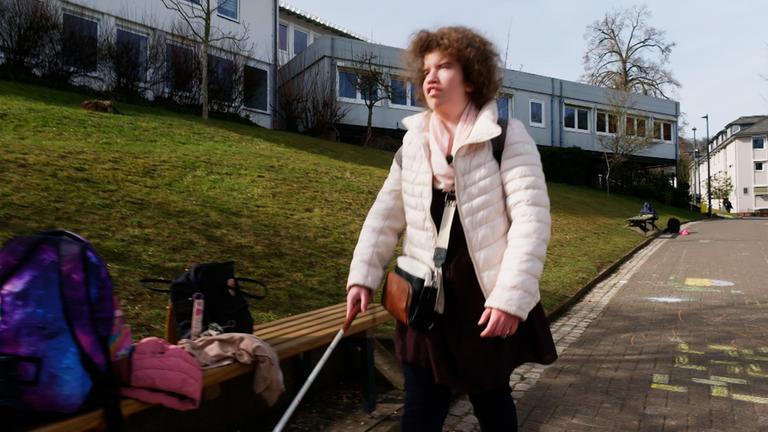 Schülerin Tabea mit Sehbehinderung auf dem Weg zur Schule.