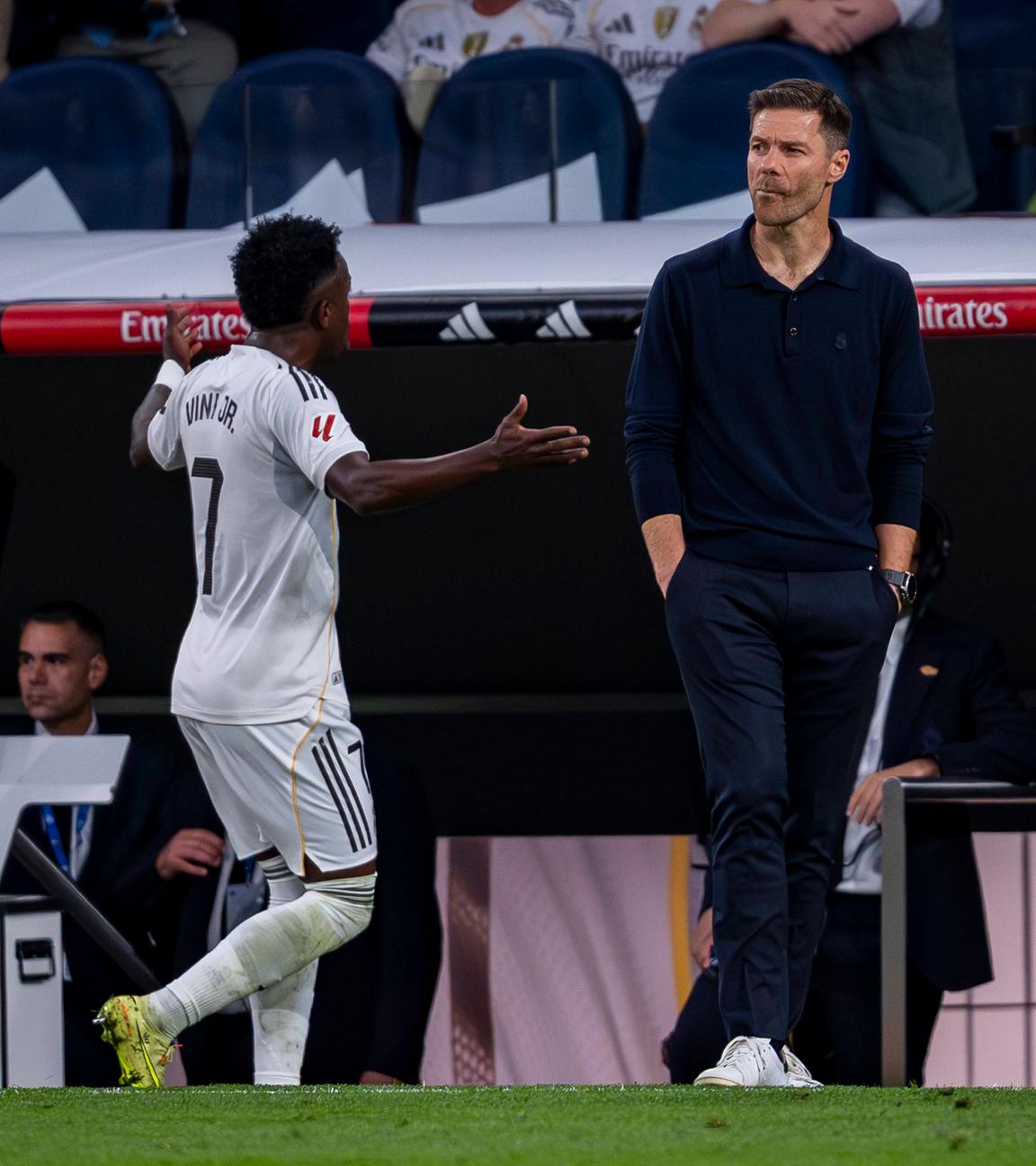 Vinicius Junior gestikuliert hinter dem Rücken von Xabi Alonso