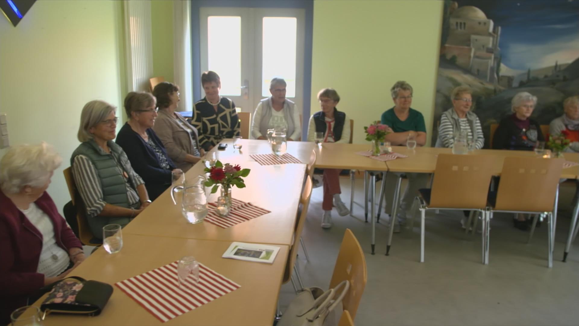 alte Menschen sitzen an einem Tisch