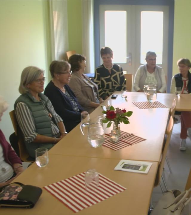 alte Menschen sitzen an einem Tisch