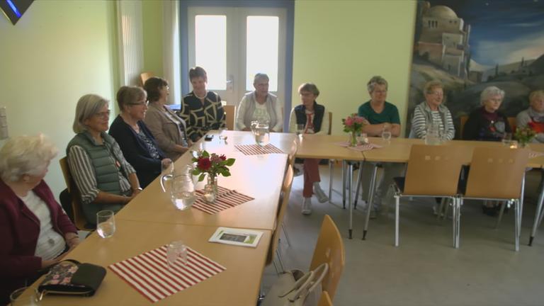 alte Menschen sitzen an einem Tisch