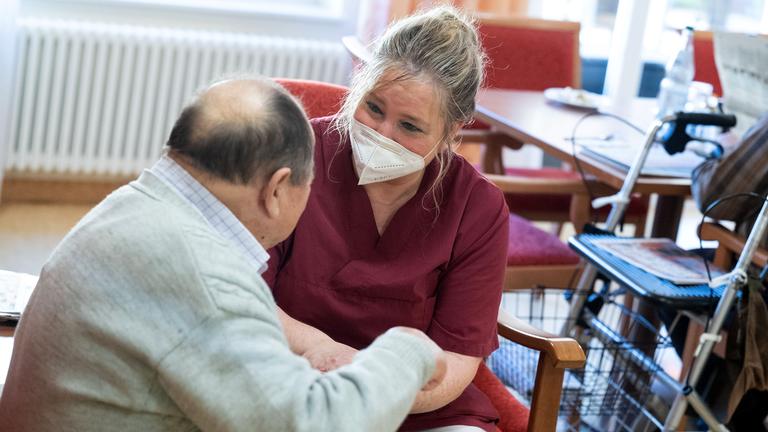 Altenpflegerin mit Seniorin im Rollstuhl, aufgenommen am 23.02.2022 in Niederstetten (Baden-Württemberg)