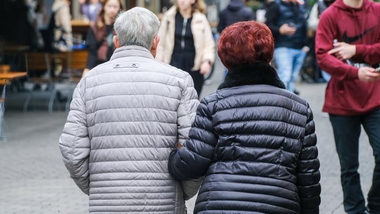 Älteres Ehepaar in der Fußgängerzone von hinten