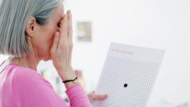 Eine ältere Frau bei einem Sehtest zur Feststellung von altersbedigter Makuladegeneration.