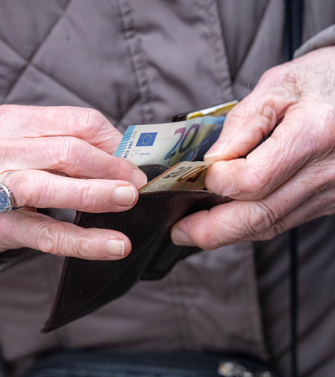 Rentner hat Geldscheine in der Hand