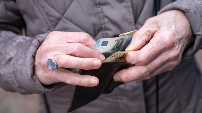 Rentner hat Geldscheine in der Hand