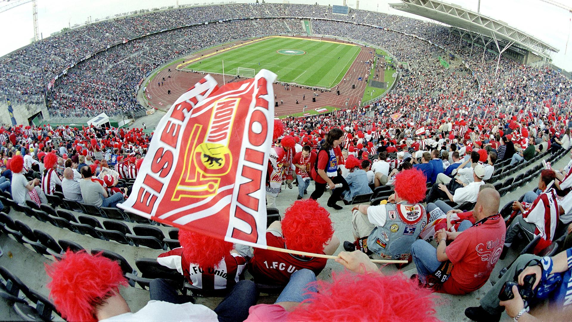 Unionfans mit Fahnen und Perücken im Olympiastadion in Berlin