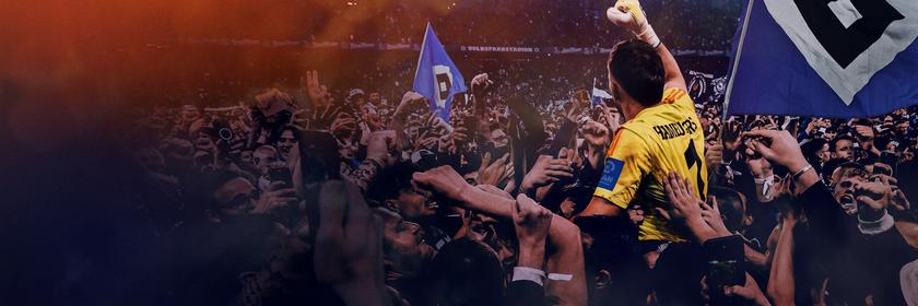 "Always Hamburg": Ein Torwart in gelbem Trikot jubelt in ener Menschenmenge in einem Fußballstadion auf den Schultern von Anhängern des Hamburger Sportvereins mit HSV-Fahnen