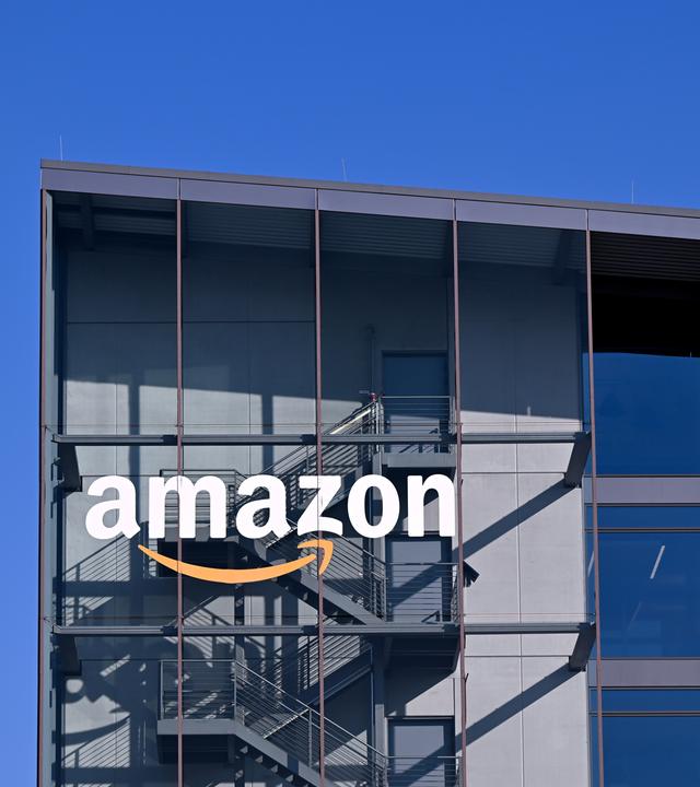 Das Logo und der Schriftzug vom Onlineversandhändler Amazon sind an der Fassade der Zentrale von Amazon Deutschland zu sehen.