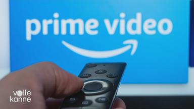 TV-Bildschirm auf dem man "prime video" geschrieben sieht und eine Fernbedienung davor