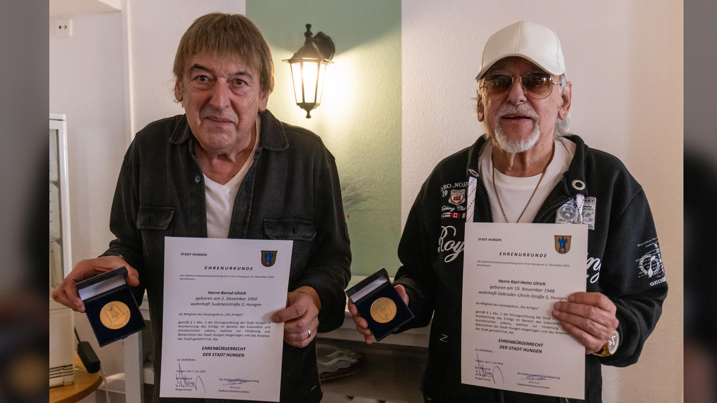 Die Brüder Bernd (l) und Karl-Heinz Ulrich, bekannt als Schlagerduo "Die Amigos", freuen sich über das Ehrenbürgerrecht der Stadt Hungen, mit dem sie im Rahmen der 32. Hungener Europawoche beim Marktplatz-Brunnenfest am 07.06.2025 ausgezeichnet wurden