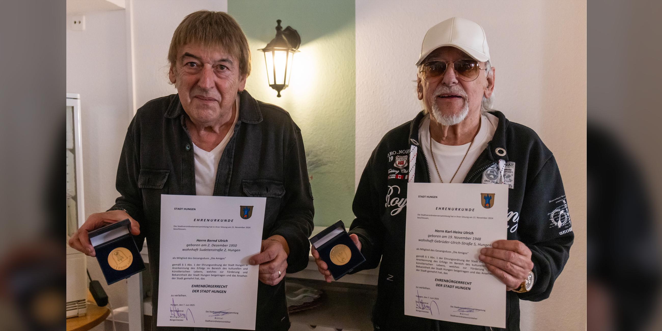 Die Brüder Bernd (l) und Karl-Heinz Ulrich, bekannt als Schlagerduo "Die Amigos", freuen sich über das Ehrenbürgerrecht der Stadt Hungen, mit dem sie im Rahmen der 32. Hungener Europawoche beim Marktplatz-Brunnenfest am 07.06.2025 ausgezeichnet wurden