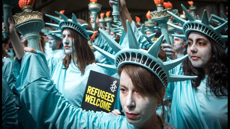 Hundert Menschenrechtsaktivisten von Amnesty International protestieren als Freiheitsstatue verkleidet vor der US-Botschaft am Londoner Grosvenor Square
