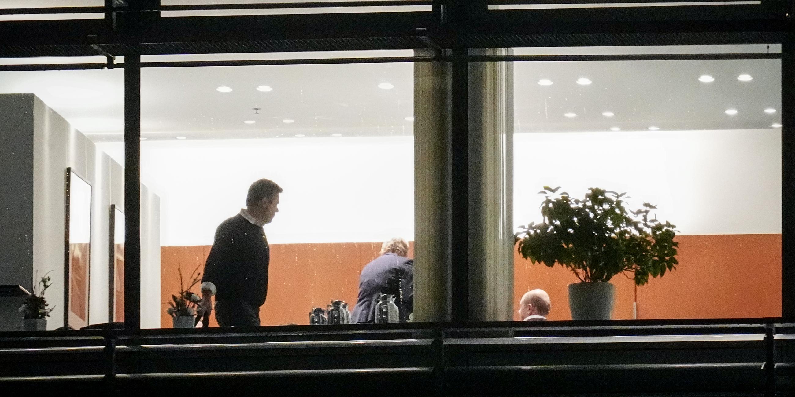 Teilnehmer der Beratungen zur Haushaltskrise verlassen einen von außen fotografierten Besprechungsraum