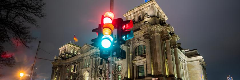 Berlin: Eine Ampel leuchtet in einer Aufnahme mit Langzeitbelichtung am Morgen vor dem Reichstagsgebäude in allen drei Phasen.