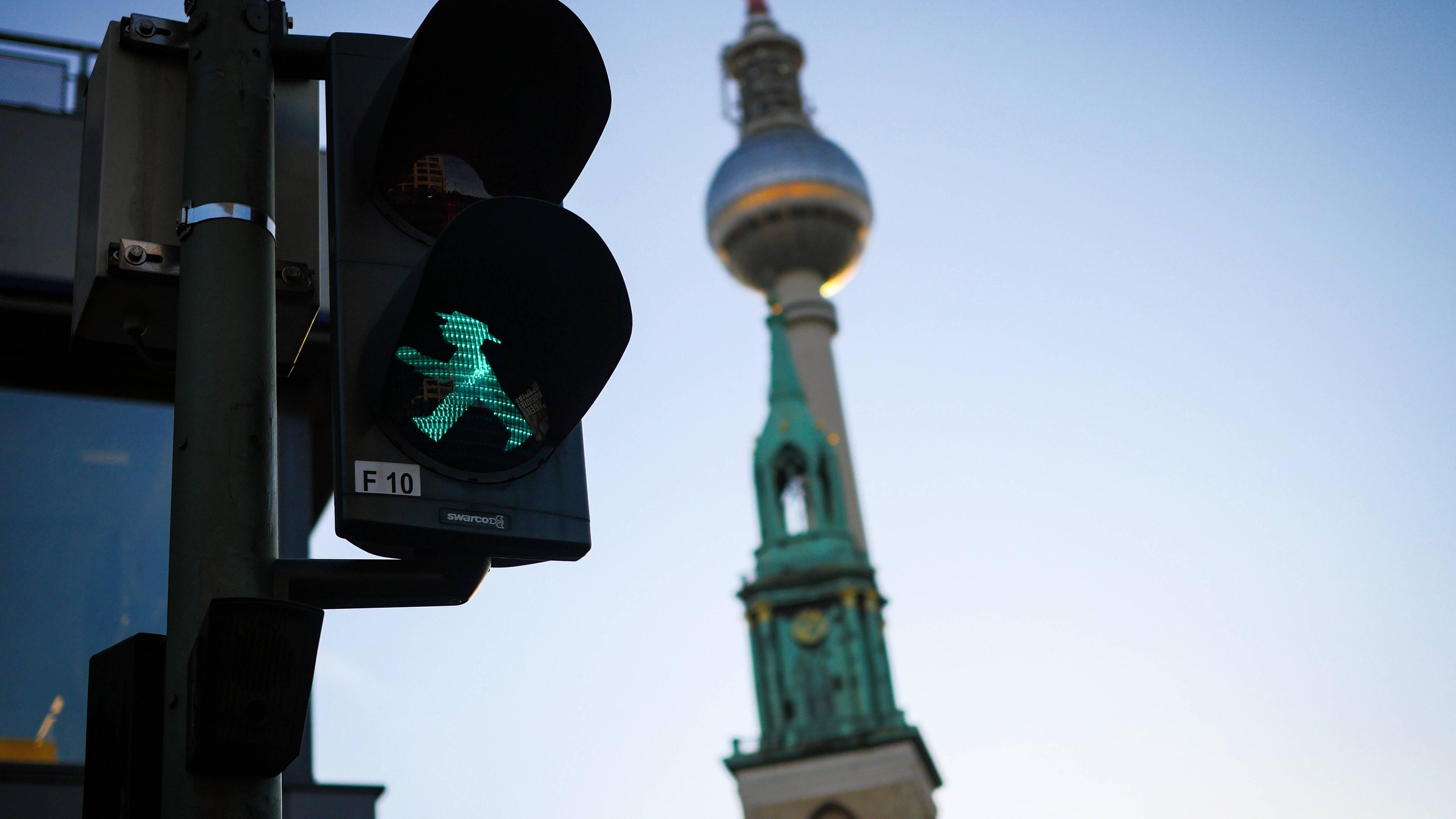 Ampel mit grünem Ampelmännchen vor dem Berliner Fernsehturm
