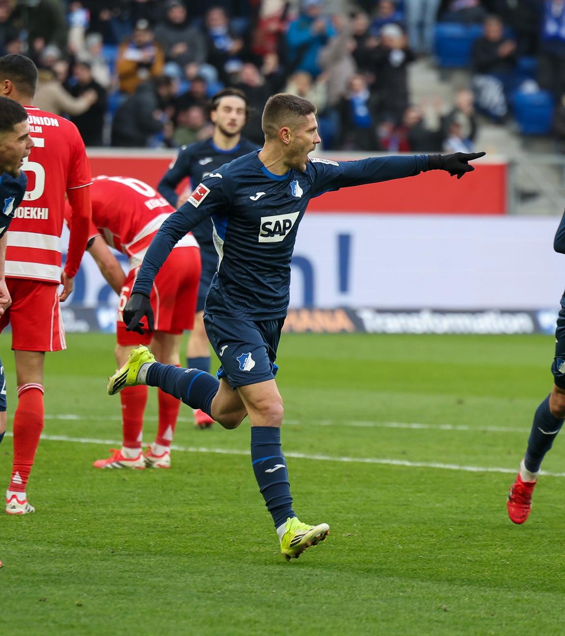 Hoffenheims offensiver Mittelfeldspieler jubelt zusammen mit seinen Teamkollegen Albian Hajdari und Grischa Proemel nach seinem Treffer zum 2:0 gegen den 1. FC Union Berlin  