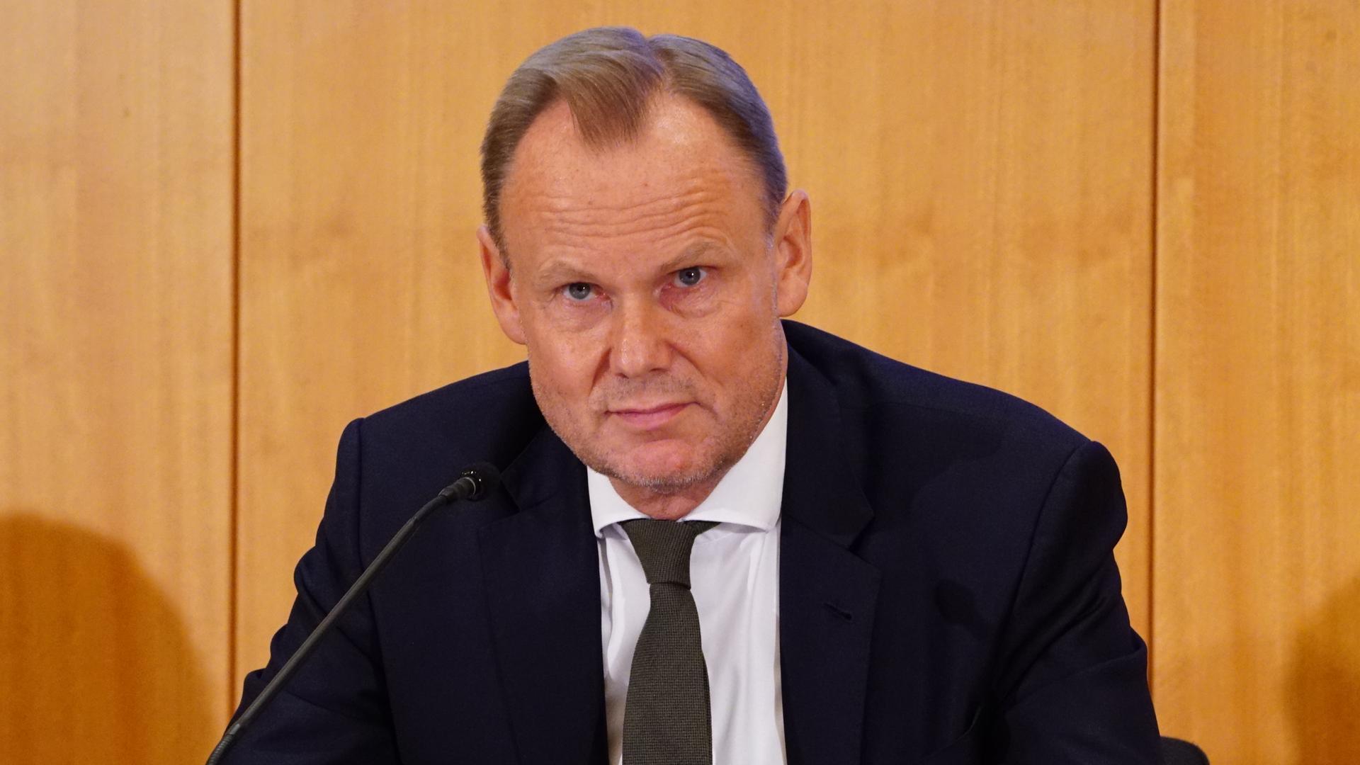 Andy Grote sitzt hinter einem Mikrofon bei einer Pressekonferenz.