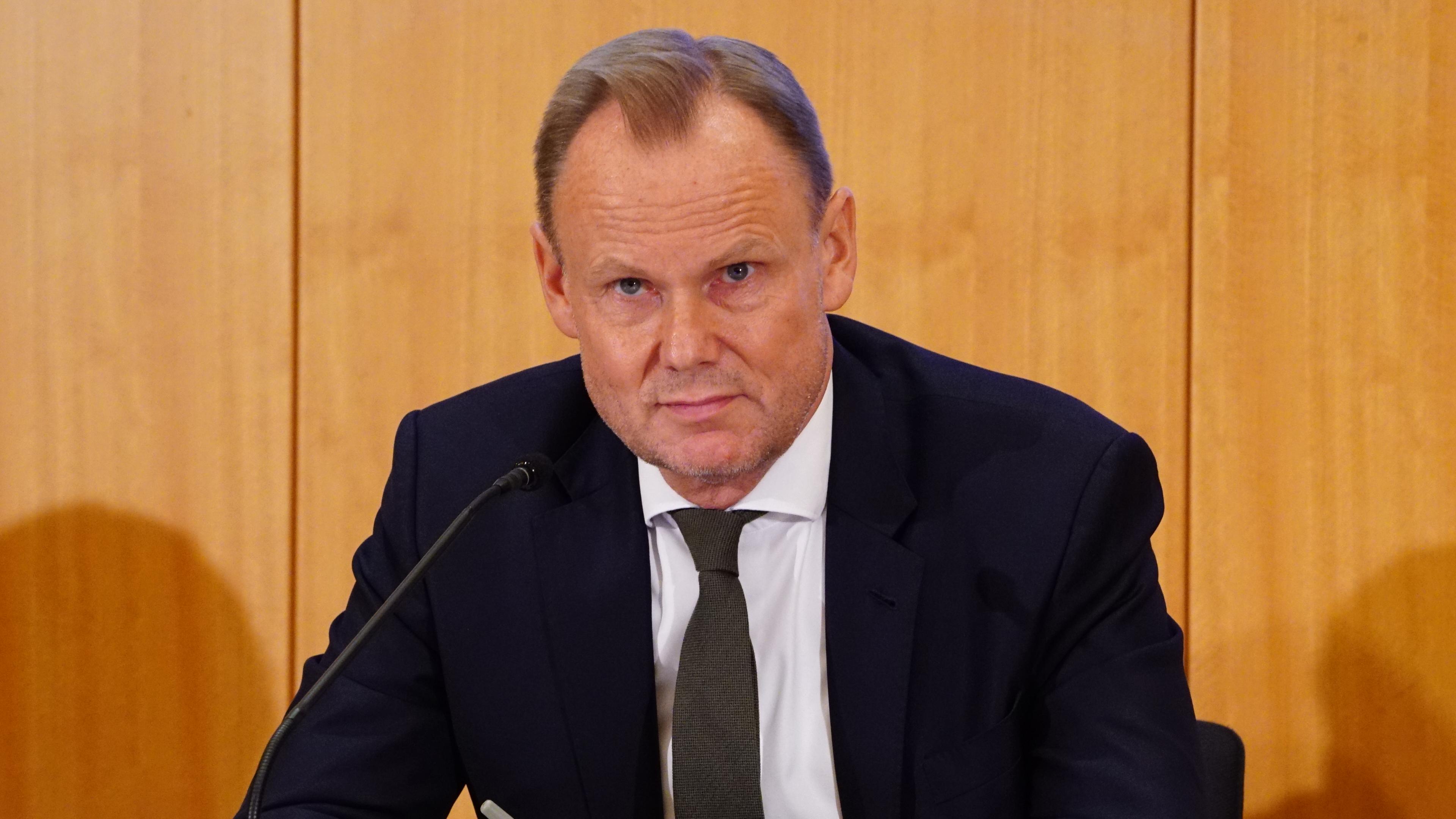 Andy Grote sitzt hinter einem Mikrofon bei einer Pressekonferenz.