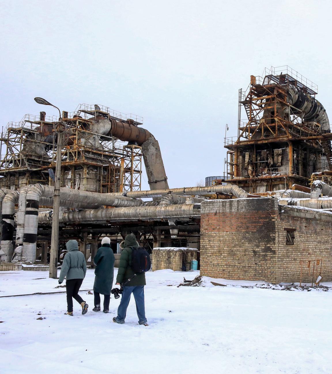 Menschen stehen am 06.02.2026 vor dem Kraftwerk CHPP-4 in Kiew, das bei einem massiven russischen Raketenangriff schwer beschädigt wurde.