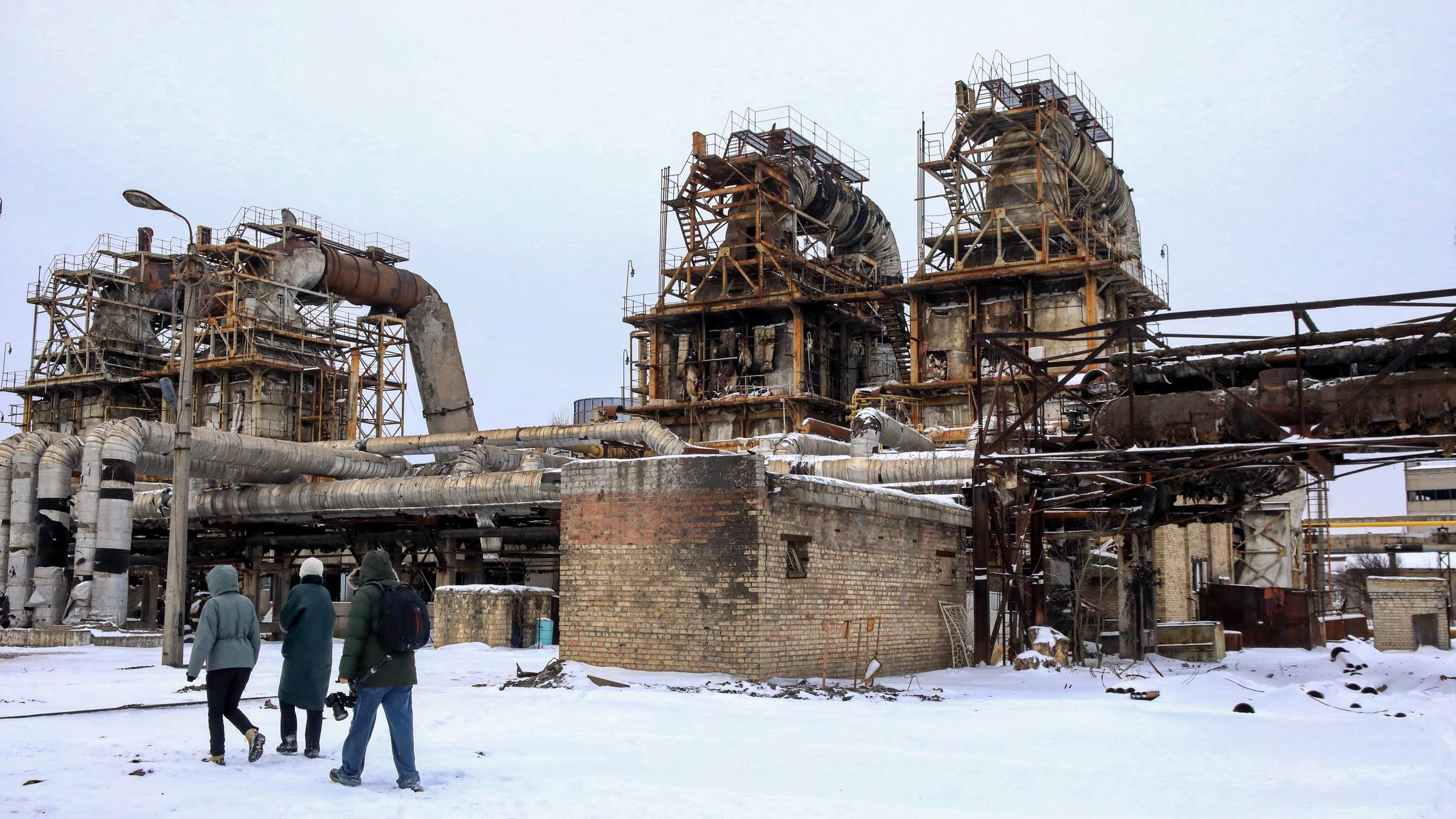 Menschen stehen am 06.02.2026 vor dem Kraftwerk CHPP-4 in Kiew, das bei einem massiven russischen Raketenangriff schwer beschädigt wurde.