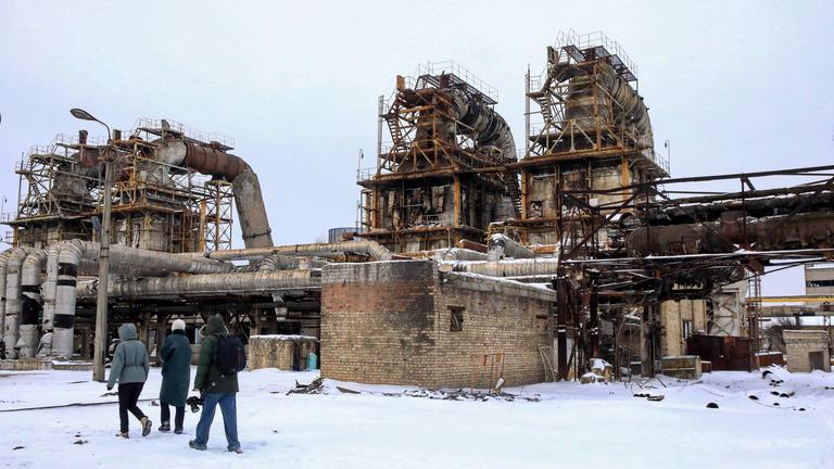 Menschen stehen am 06.02.2026 vor dem Kraftwerk CHPP-4 in Kiew, das bei einem massiven russischen Raketenangriff schwer beschädigt wurde.