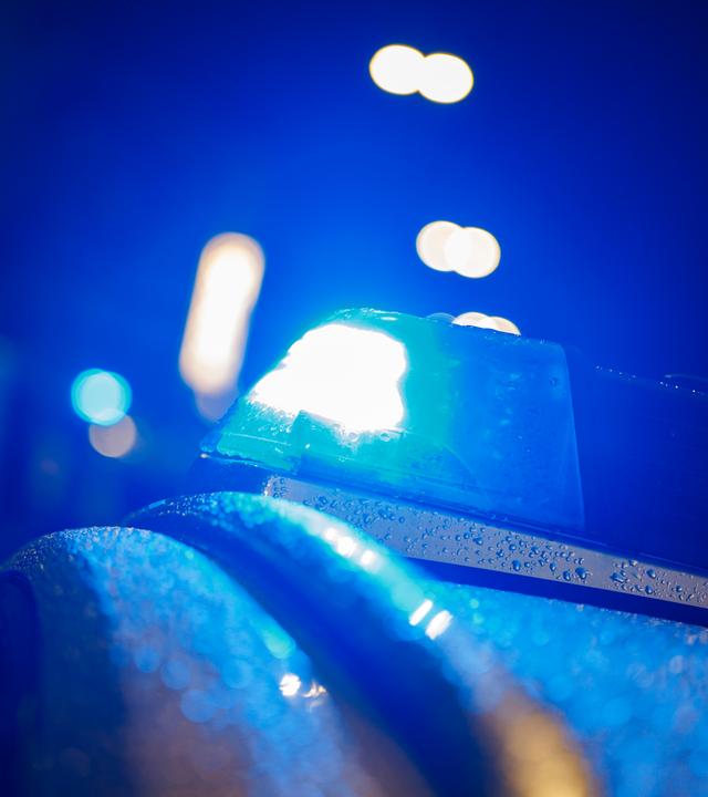 Das Blaulicht auf dem Dach eines Polizeifahrzeugs leuchtet. 