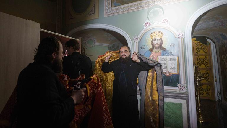 Ein Priester trägt während eines russischen Angriffs Kirchengeräte aus der brennenden Mariä-Entschlafens-Kathedrale der Kiewer Höhlenkloster (Kyiv-Pechersk Lavra) am 15.06.2026 heraus. 