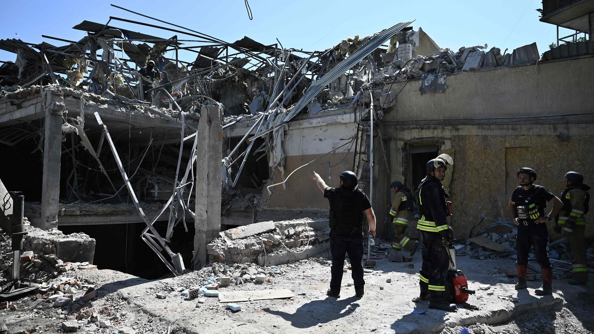 Ukrainische Rettungskräfte stehen vor einem zerstörten Hotel in Kramatorsk.